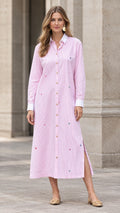 Front full view of woman wearing pink striped embroidered maxi shirt dress with white collar