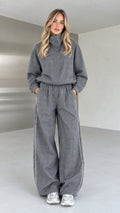 Full front view of model wearing grey plaid high-neck top and wide-leg pants set
