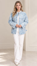 Front view of model wearing light blue floral lace jacket with pearl collar