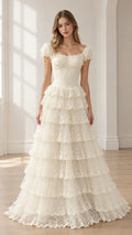 Front full-length view of woman wearing ivory tiered lace corset maxi dress