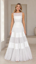 Front view of model wearing white sleeveless tiered tulle and satin formal gown