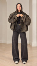 Front view of model wearing brown leopard print oversized hooded jacket with dark grey wide leg jeans