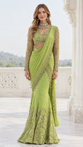Front full-length view of model in lime green pre-draped saree gown with embroidered sheer blouse