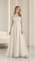Front full-length view of model wearing ivory embellished high-neck long sleeve maxi gown