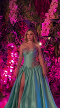 Front view of woman wearing turquoise strapless corset evening gown with high slit and embroidery