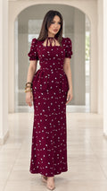 Front view of model wearing burgundy floral print peplum maxi dress with puff sleeves