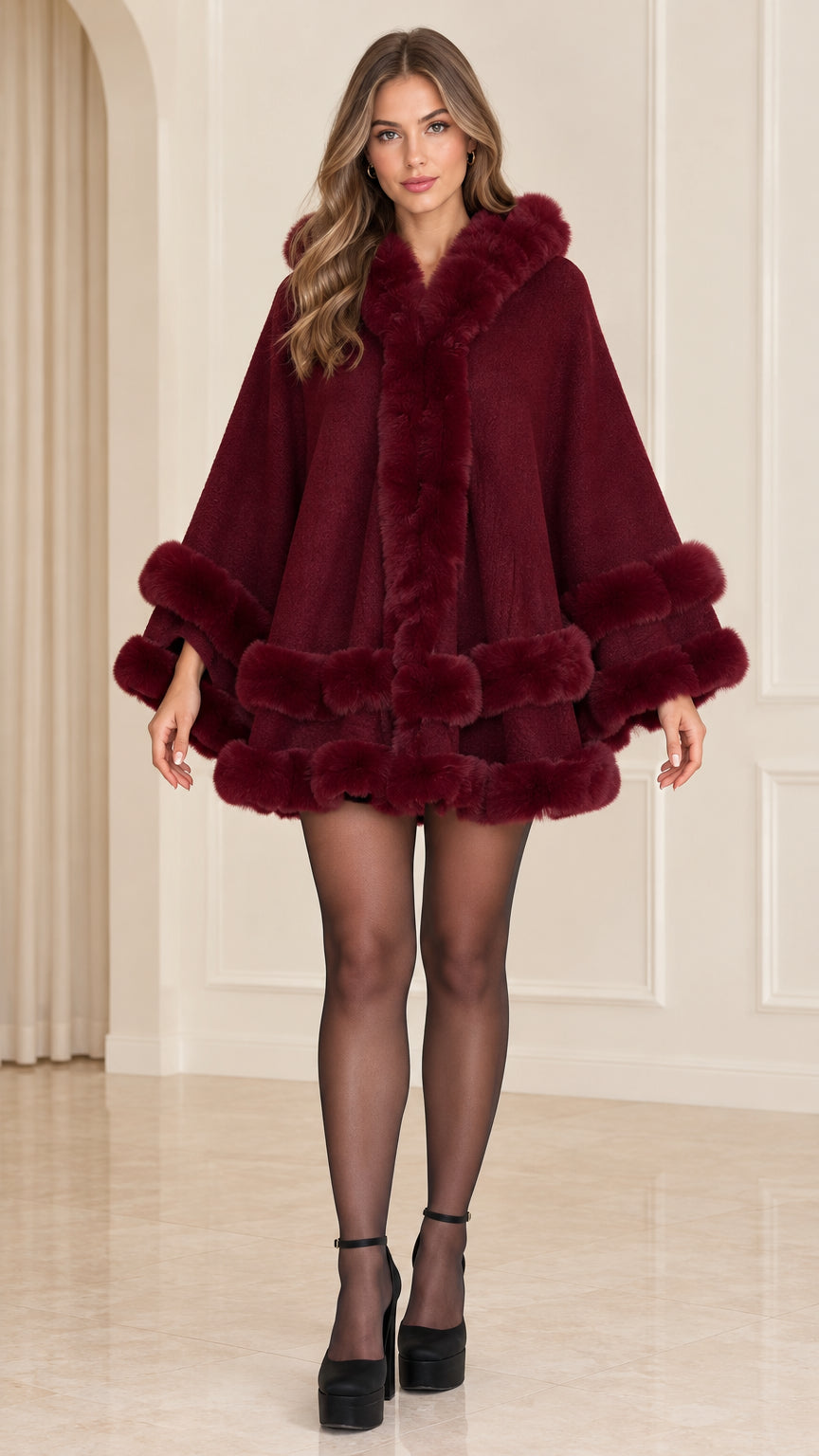 Front full view of woman wearing burgundy faux fur trim hooded cape coat