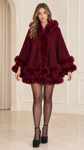 Front full view of woman wearing burgundy faux fur trim hooded cape coat