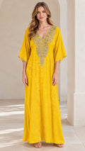 Full front view of a woman wearing a bright yellow embroidered V-neck kaftan maxi dress