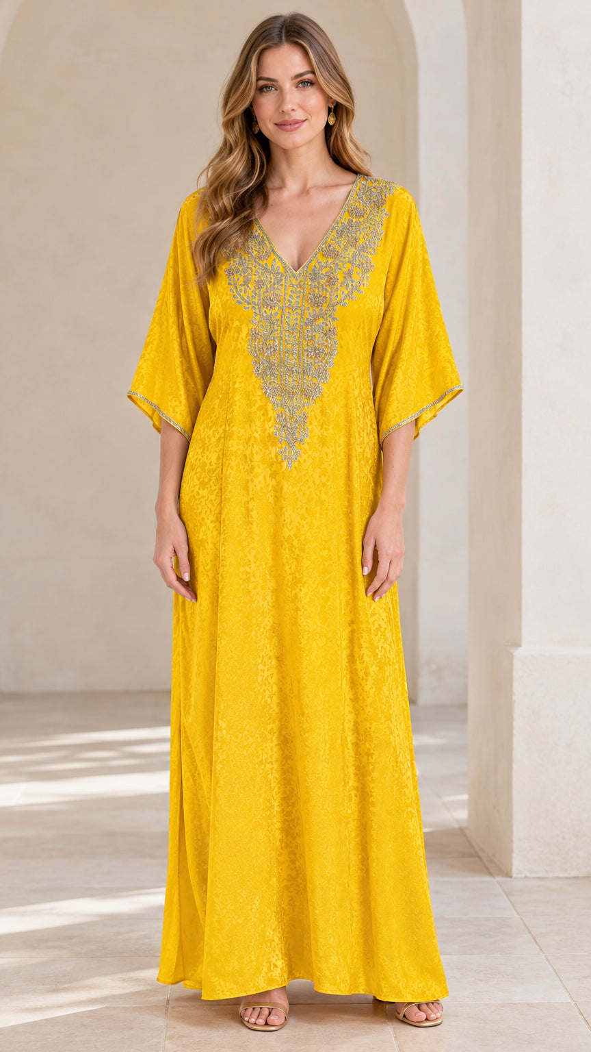 Full front view of a woman wearing a bright yellow embroidered V-neck kaftan maxi dress