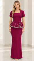 Front view of model wearing Burgundy square neck peplum maxi evening gown with beaded waist trim