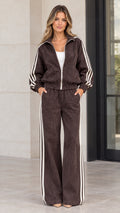 Front full view of woman wearing brown corduroy zip-up jacket and matching wide-leg striped pants