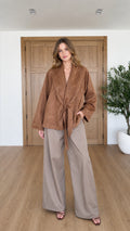 Front full view of woman wearing Camel faux suede tie-front jacket with wide-leg trousers