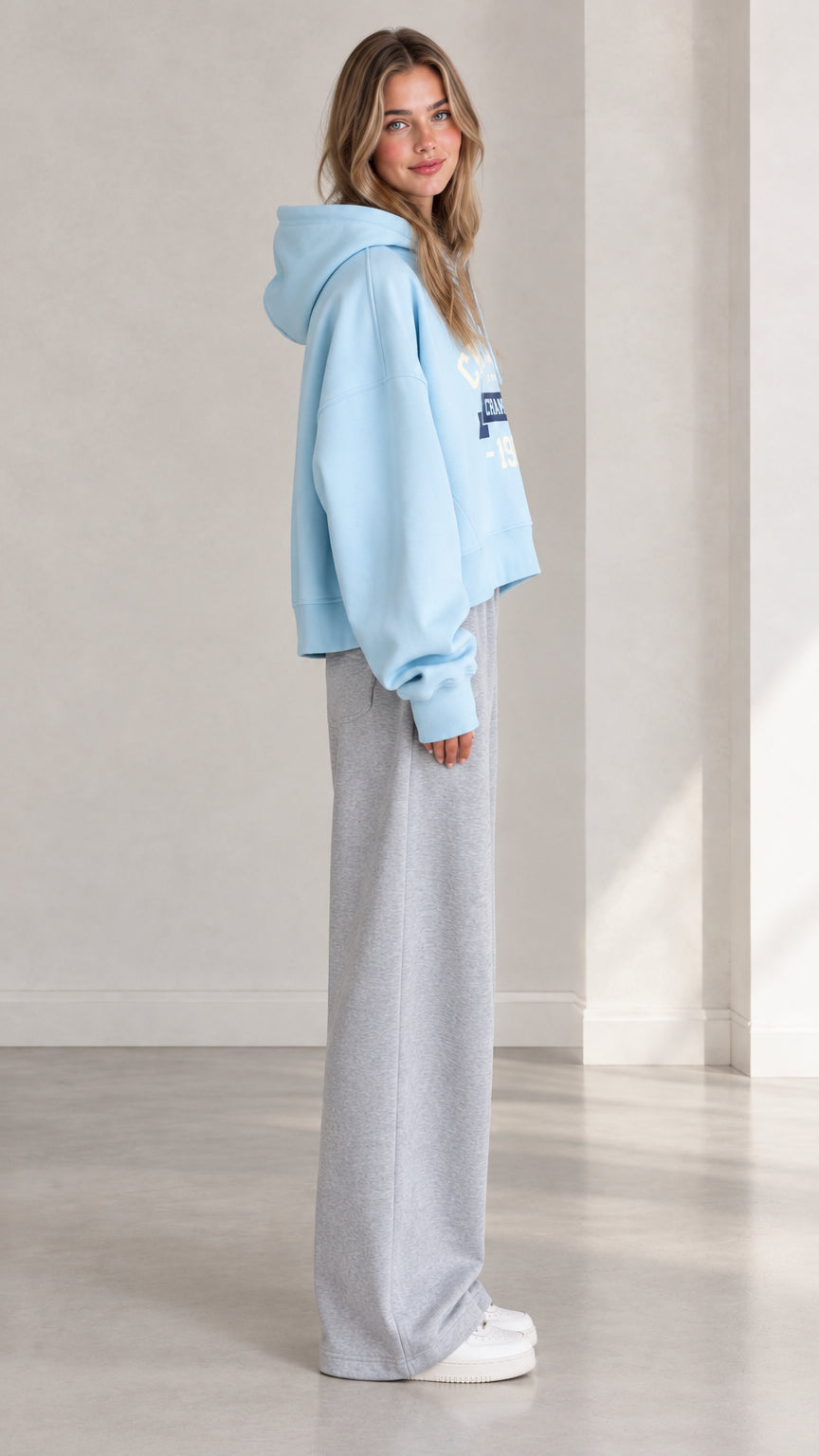 Side profile view of woman wearing Light Blue cropped fleece hoodie