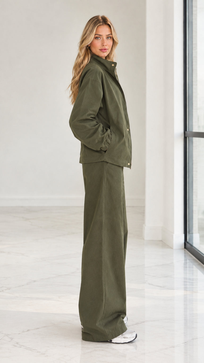Side profile view of woman wearing olive green 2-piece zip jacket and wide leg pants set