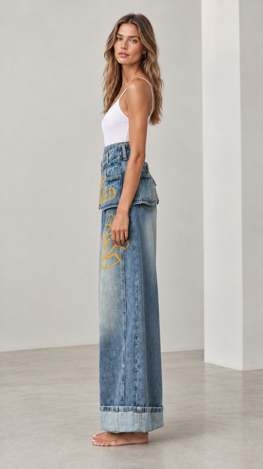 Side profile view of Washed Blue Fold-Over Waist Graphic Wide-Leg Jeans
