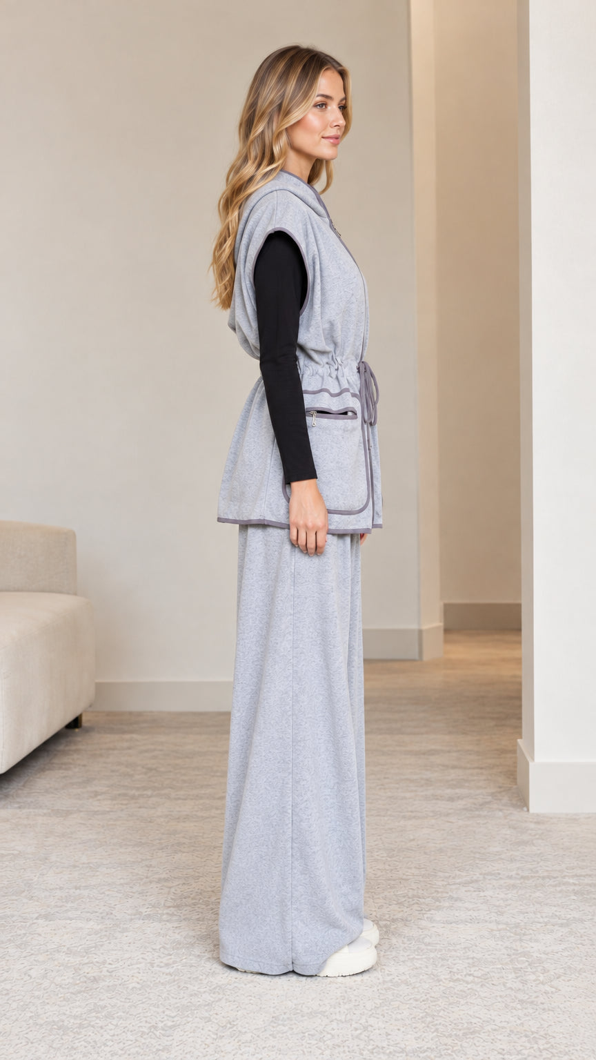 Side profile view of model in heather grey drawstring hooded vest and relaxed trousers