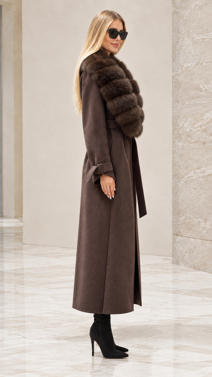 Side profile of woman wearing brown belted maxi coat with faux fur trim
