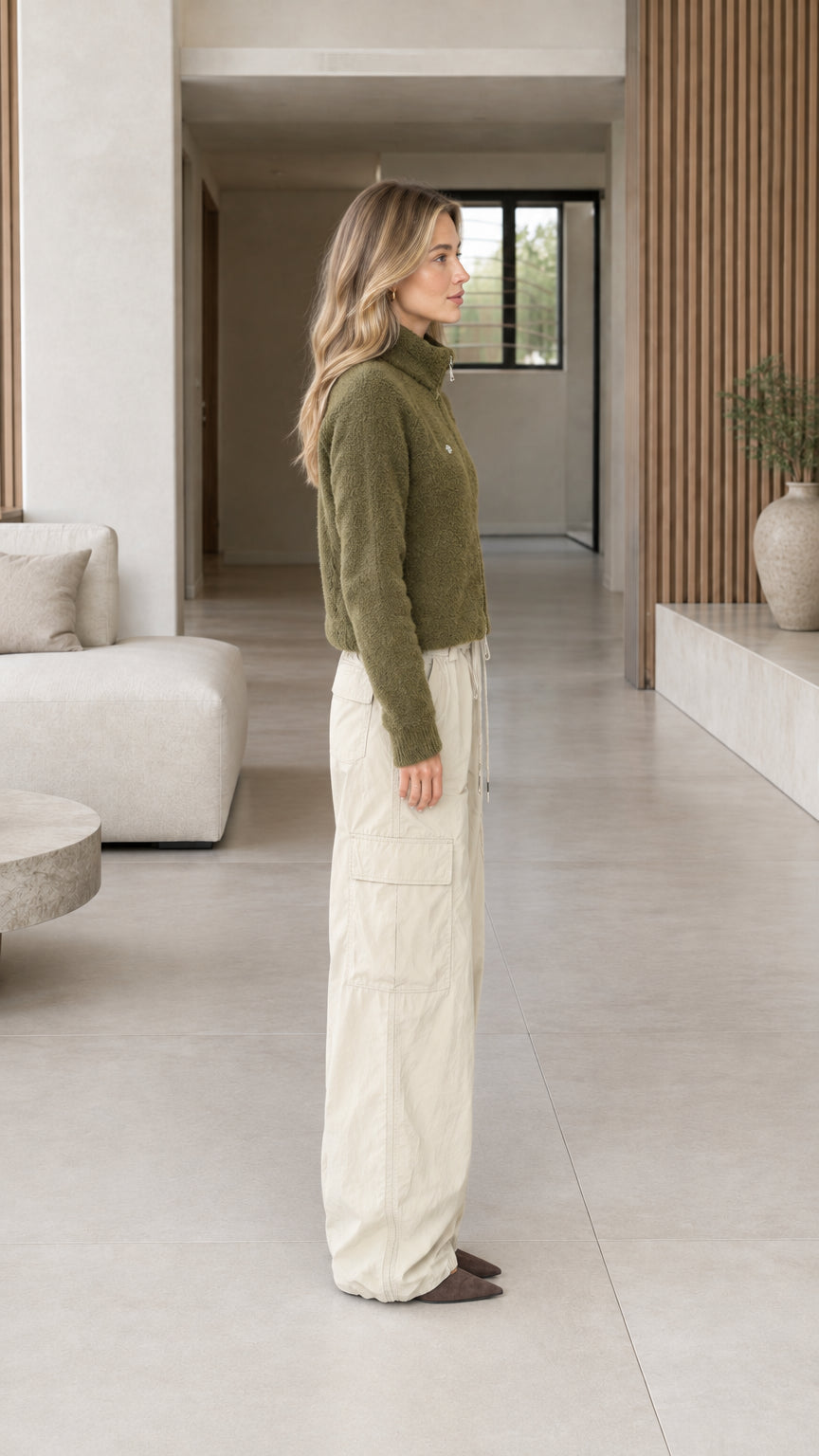 Side profile view of model wearing olive green cropped fleece jacket