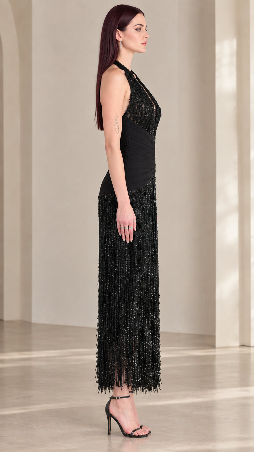 Side profile view of black halter sequin fringe dress with cinched waist