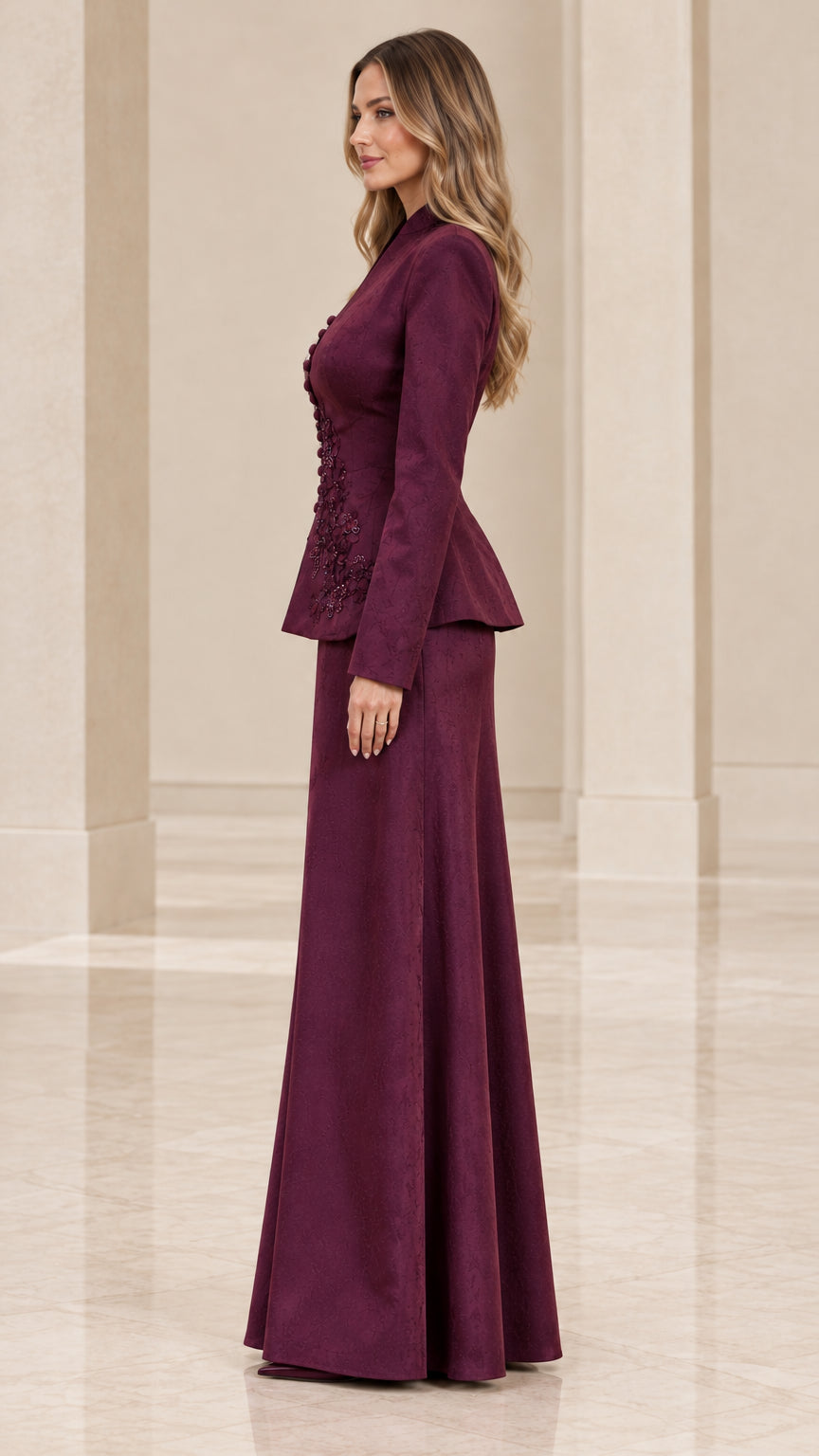 Side profile view of burgundy embroidered two-piece evening skirt suit