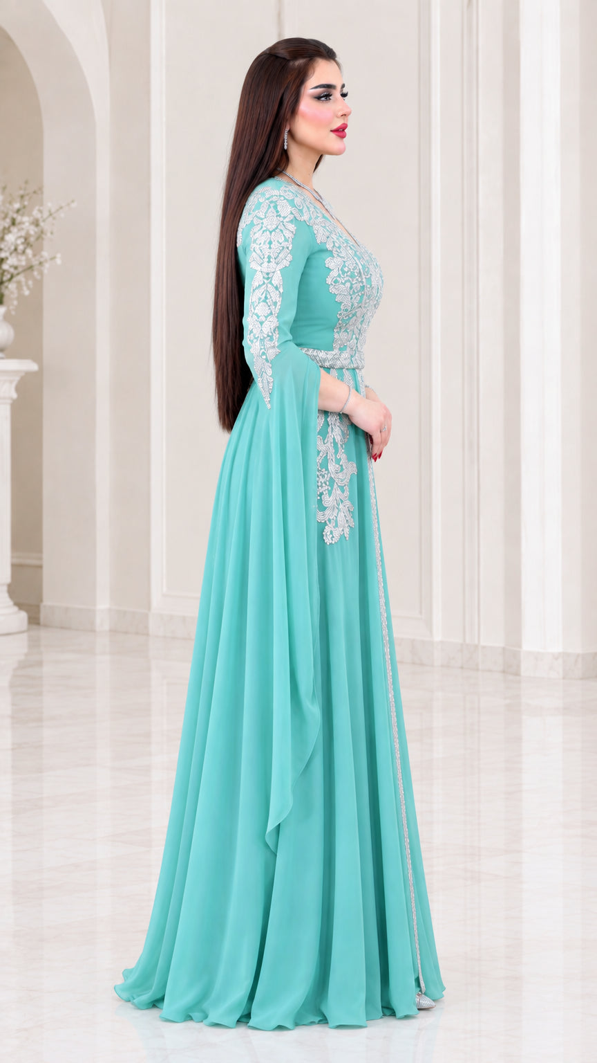Side profile view of aqua embroidered cape sleeve evening gown
