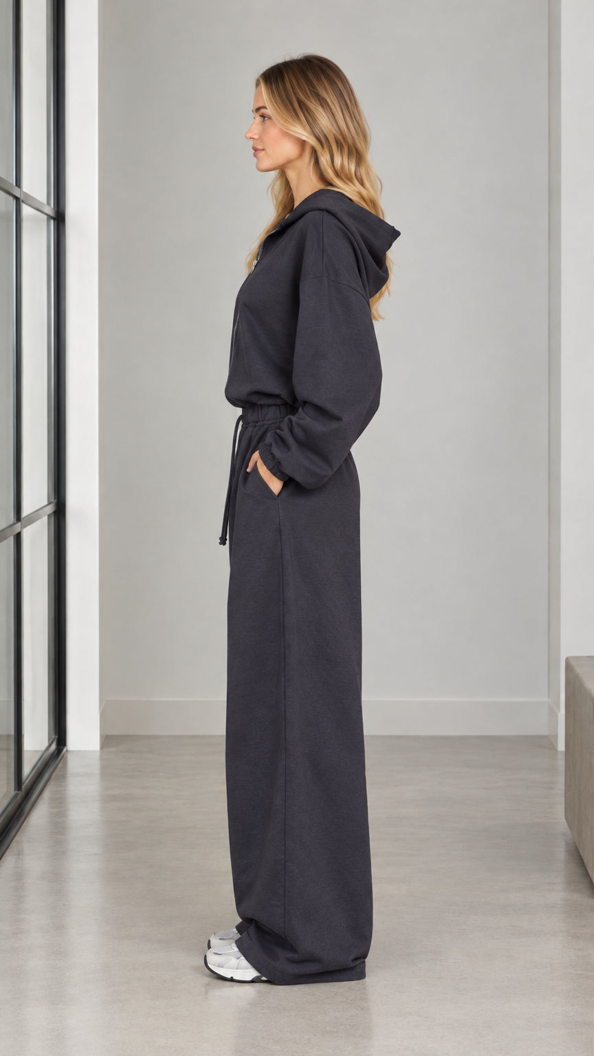 Side profile view of woman modeling the charcoal hooded wide-leg jumpsuit