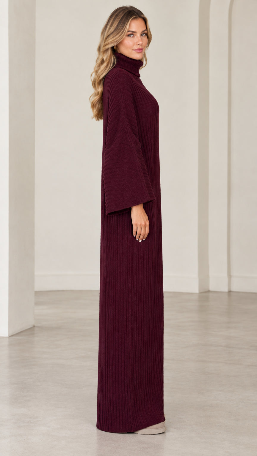 Side profile view of model wearing burgundy ribbed maxi dress