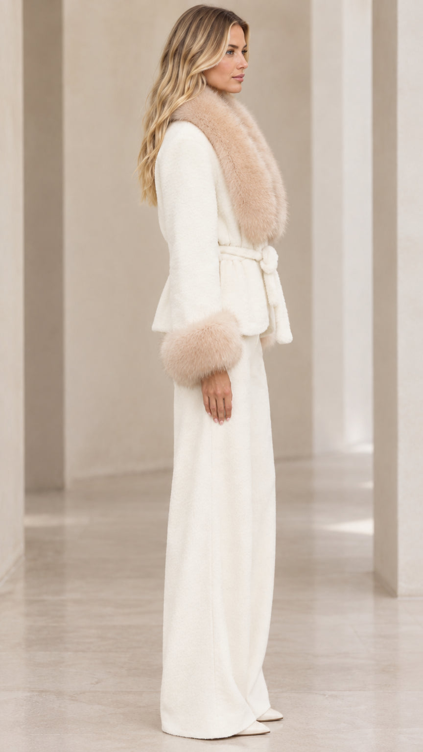 Side profile of woman in cream faux fur trim jacket and matching palazzo pants