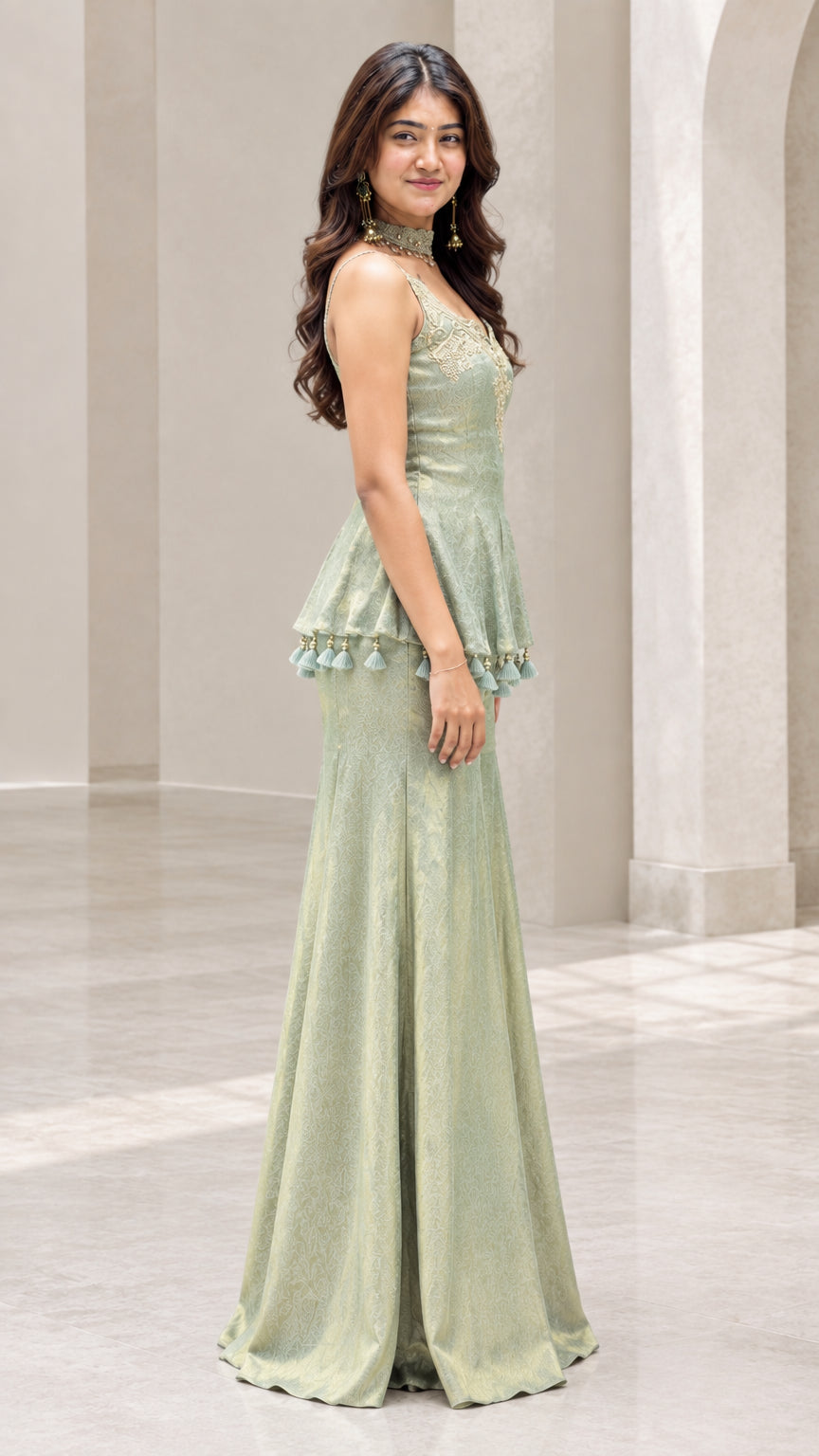 Side full view of woman in sage green sleeveless peplum sharara suit set