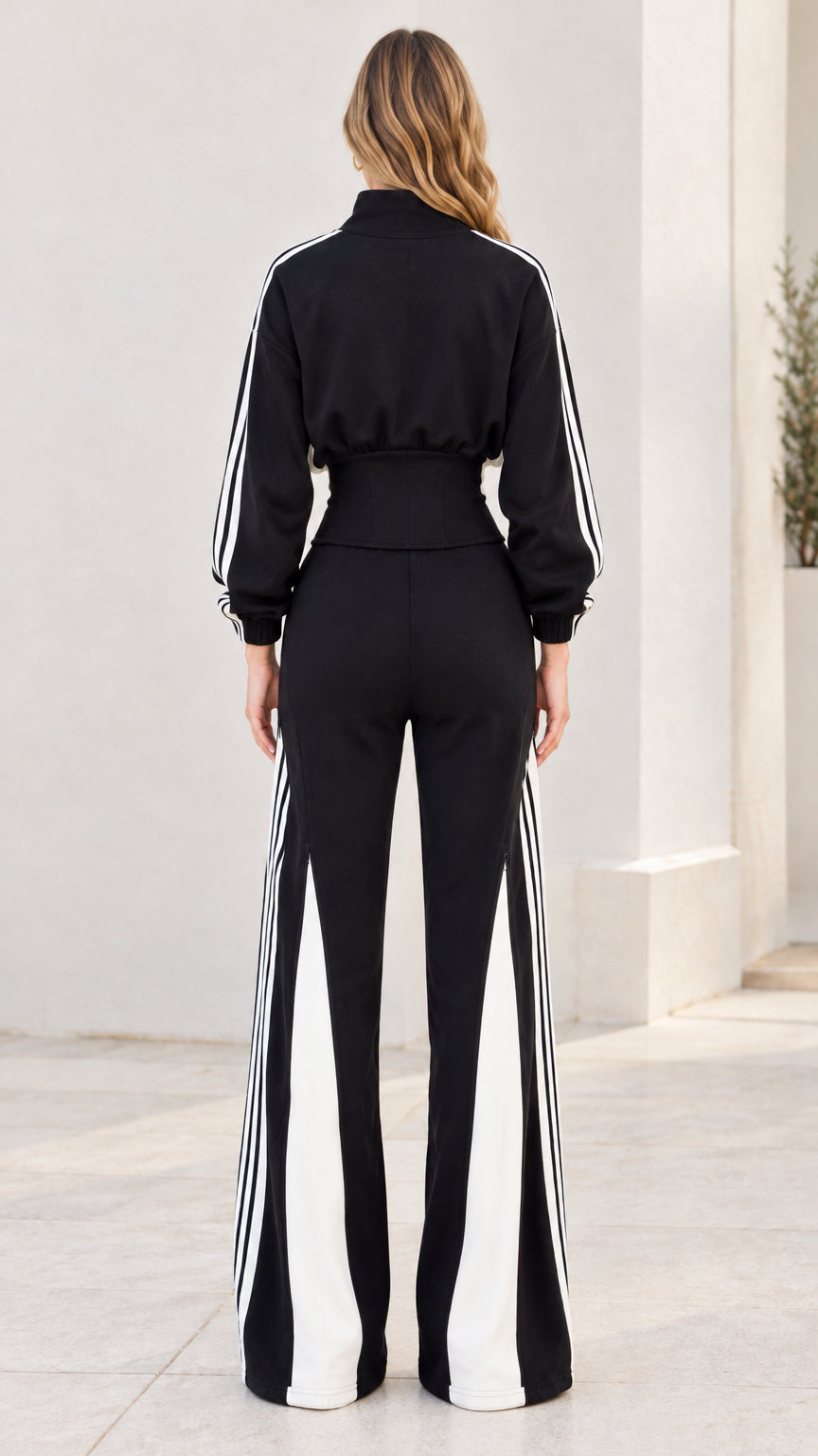 Back view of model wearing black zip jacket and wide-leg track pants