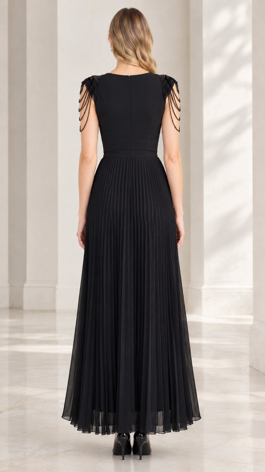 Back view of black floor-length formal dress showing sleek back and pleated skirt