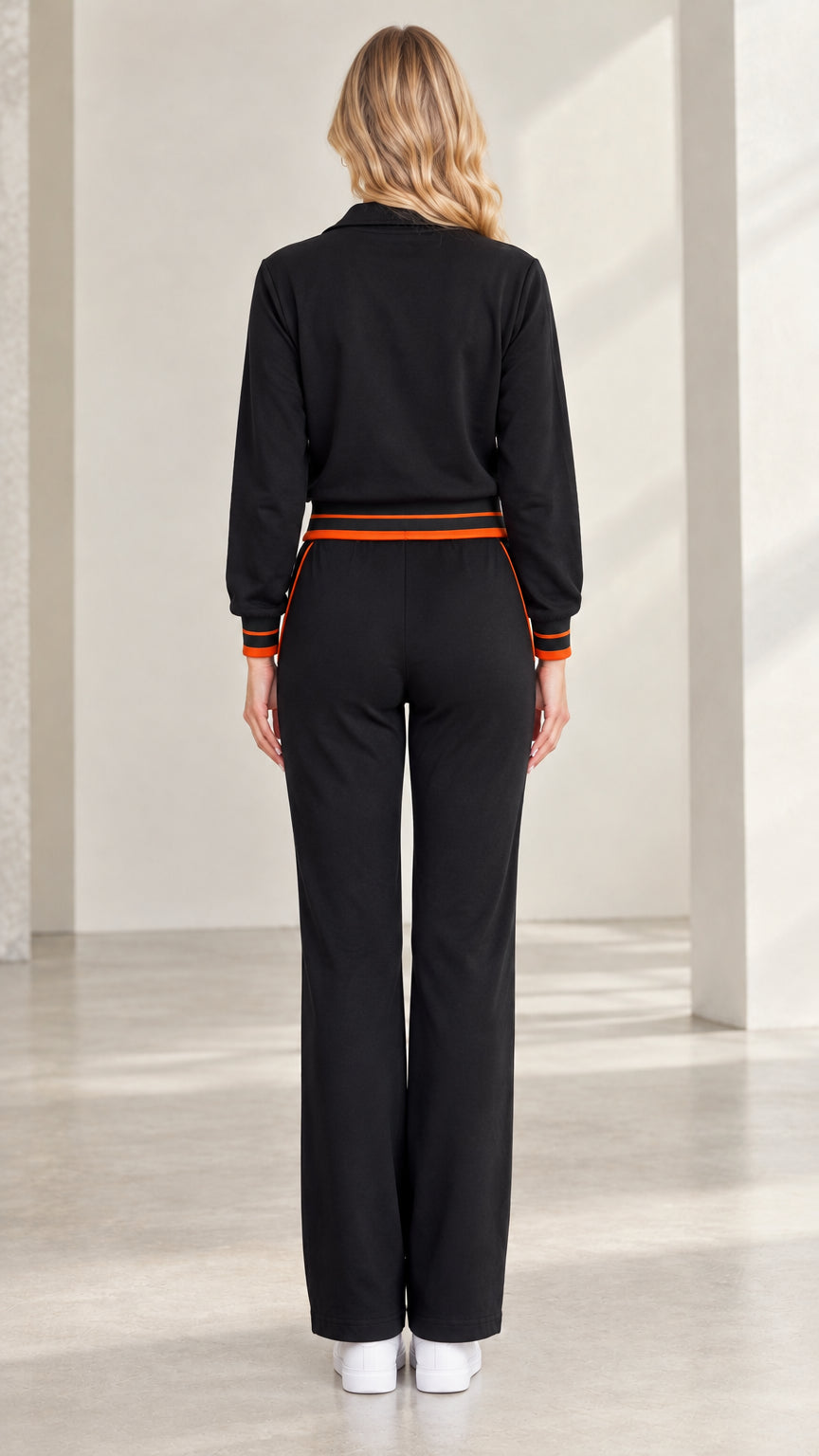 Back view of woman wearing black zip-up tracksuit with straight wide legs