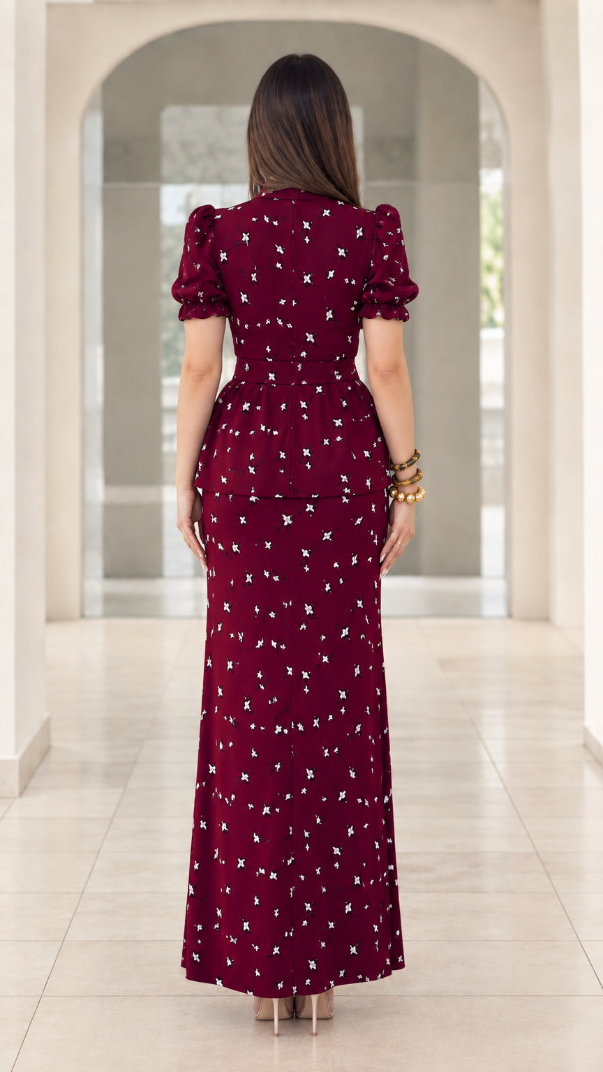 Back view of model wearing burgundy floral peplum maxi dress showing fitted silhouette