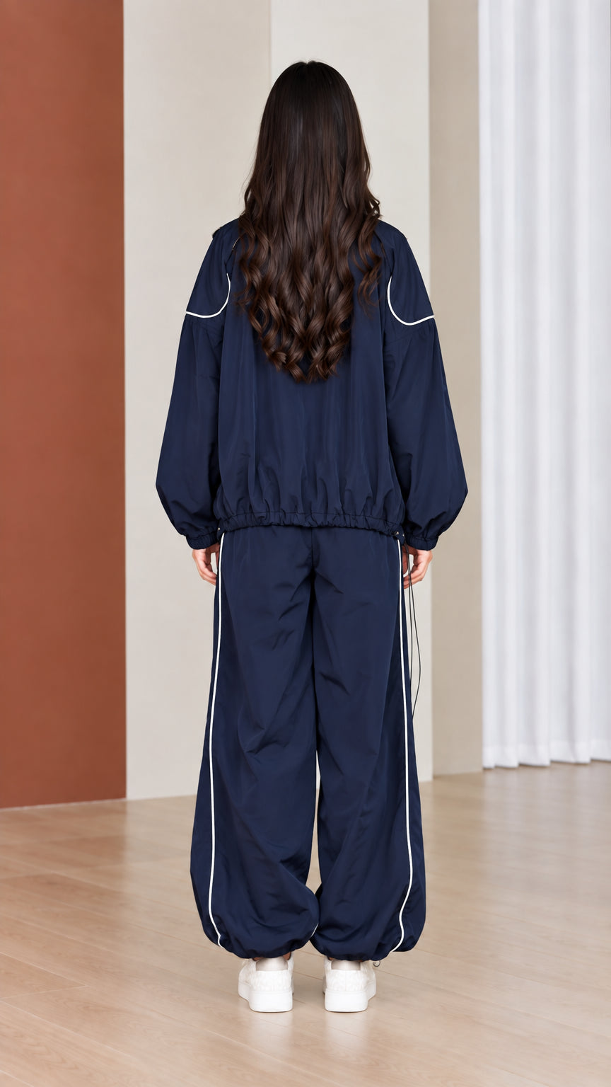 Back view of navy blue tracksuit set showing relaxed jacket hem and straight leg cut