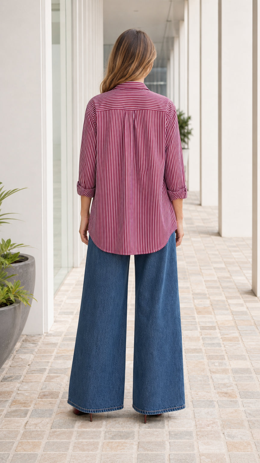 Woman wearing burgundy striped button down shirt, back view