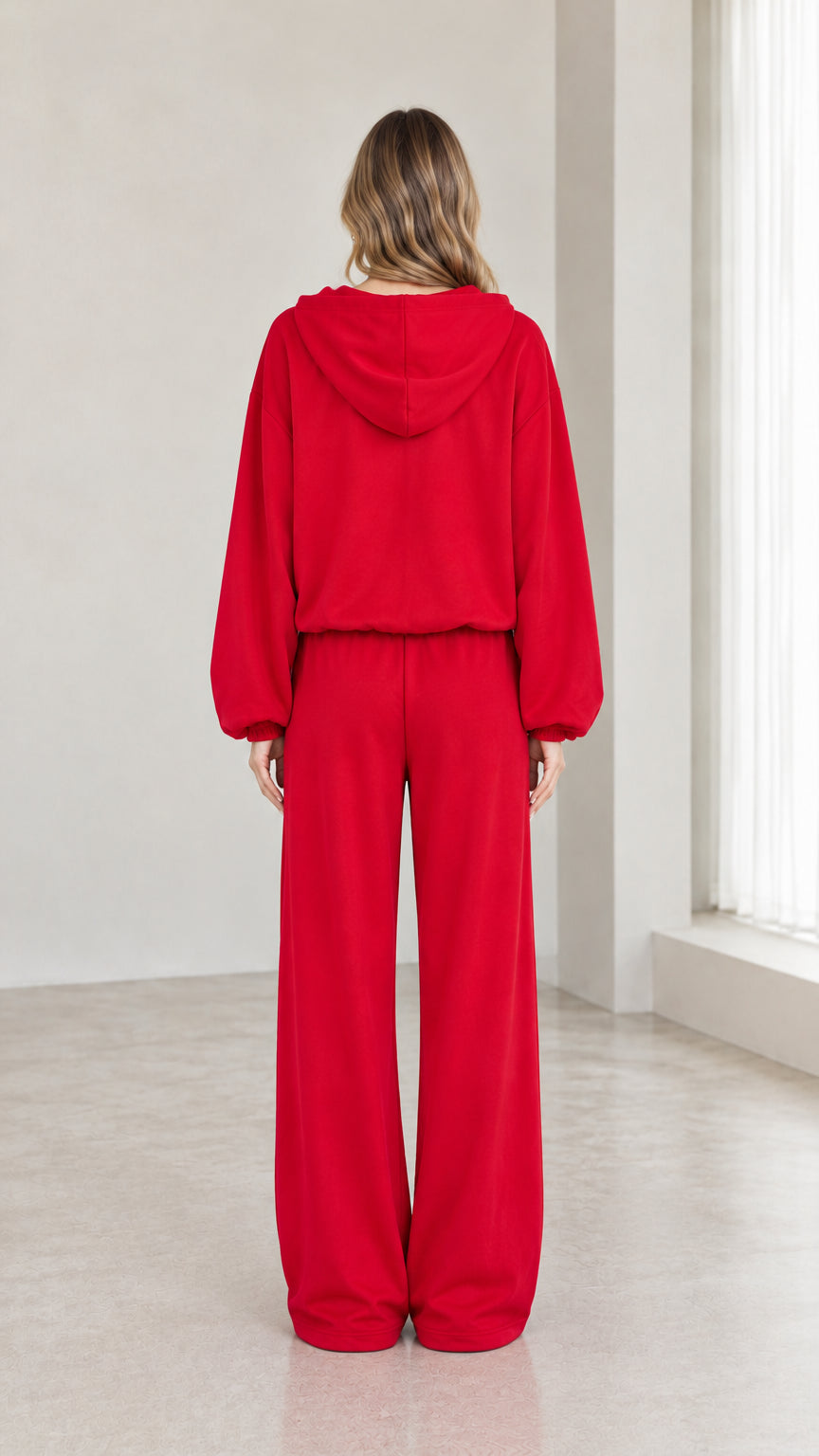 Back view of woman wearing red hooded tracksuit set