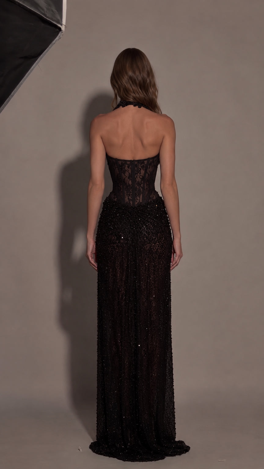 Back view of black halter corset maxi dress highlighting open back design