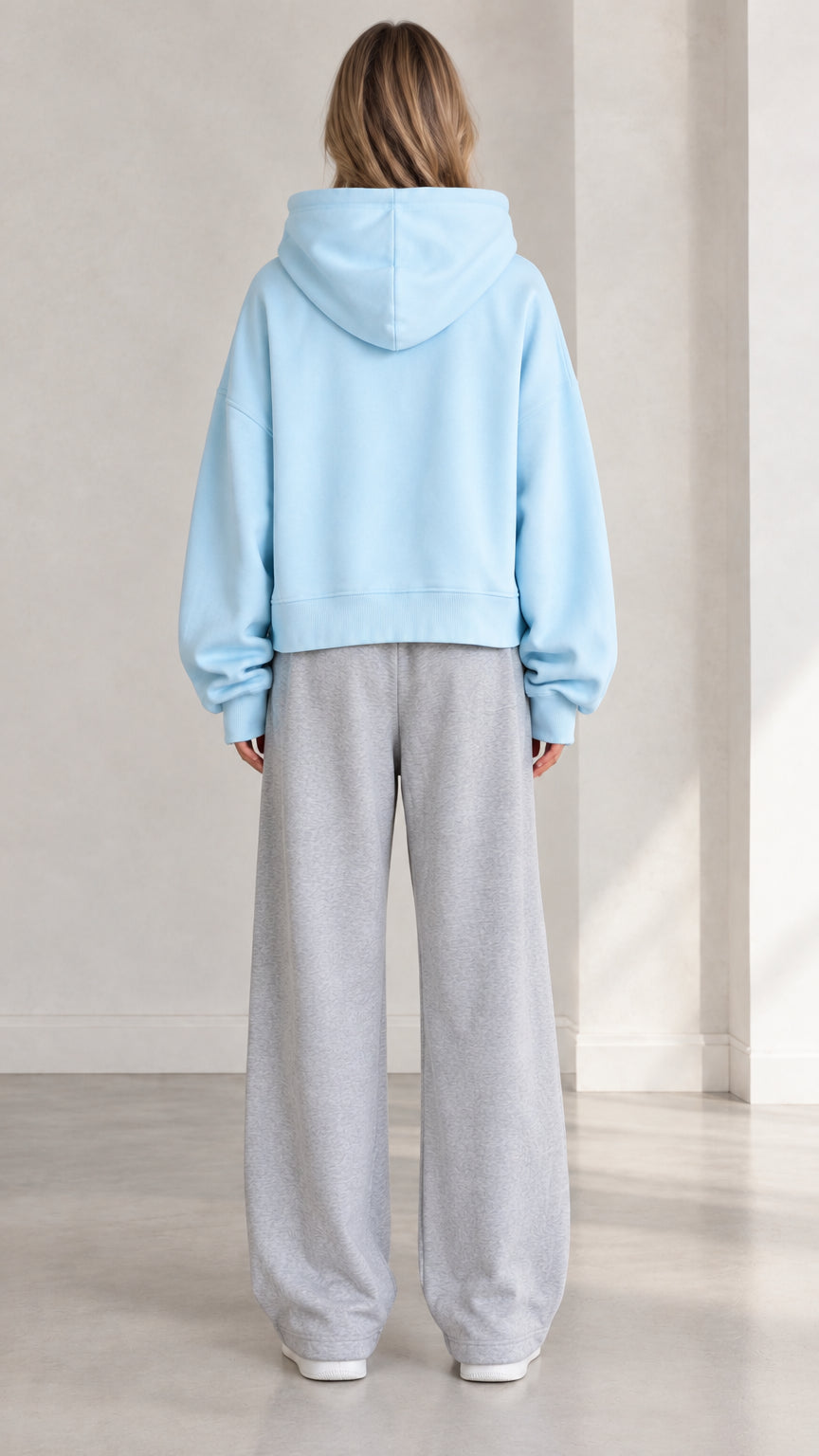 Back view of woman wearing Light Blue cropped hoodie showing relaxed fit and hood