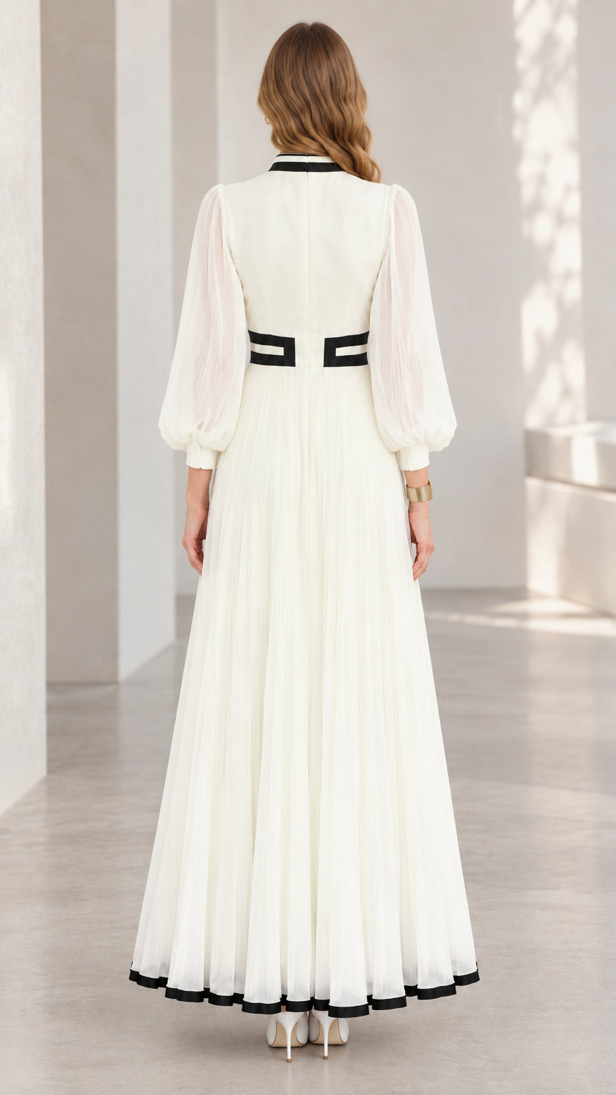 Back full-length view of white high-neck pleated maxi dress with black accents