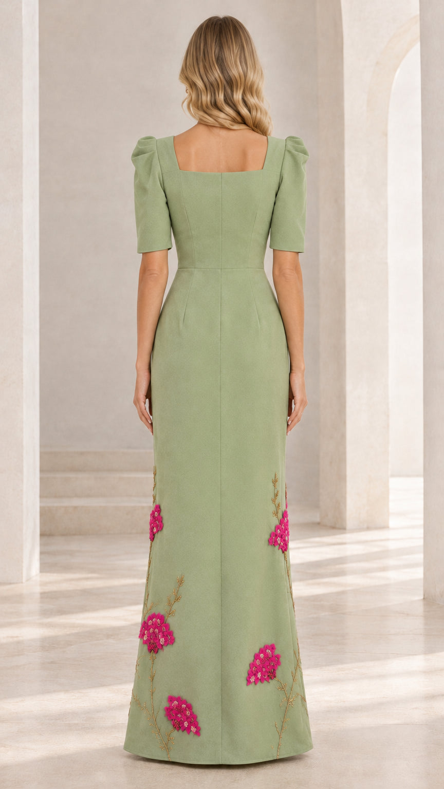 Back full view of woman in sage green maxi gown showing back neckline and hem embroidery