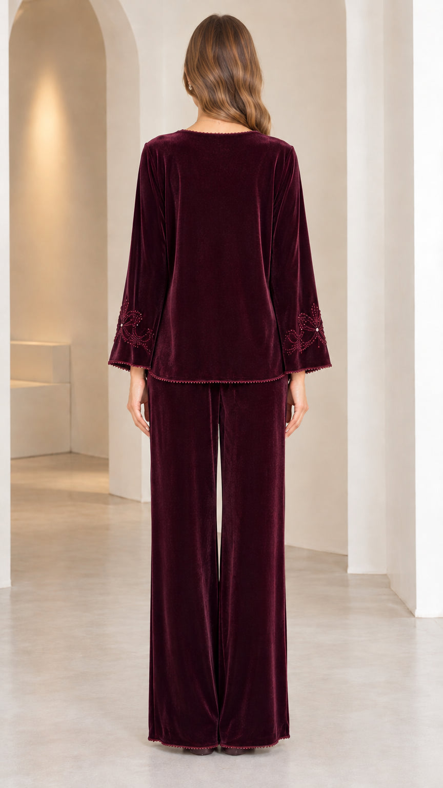 Back view of model in Burgundy velvet long-sleeve top and wide-leg trousers
