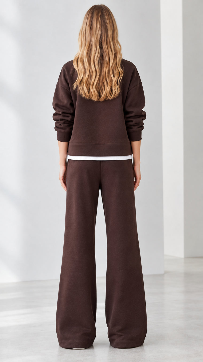 Back view of model wearing brown quarter-zip loungewear set with white contrast trim