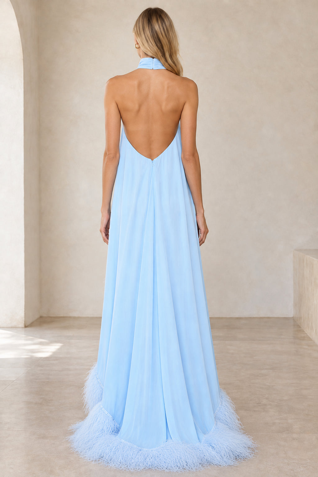 Back view of model wearing sky blue backless halter evening dress