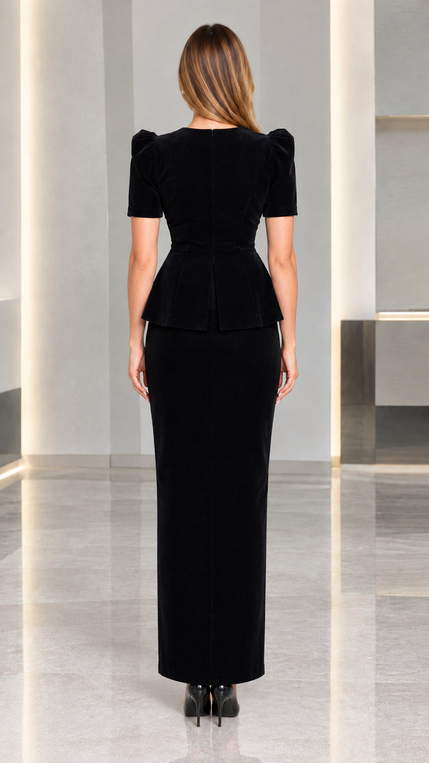Back view of model wearing black tailored peplum top and long skirt