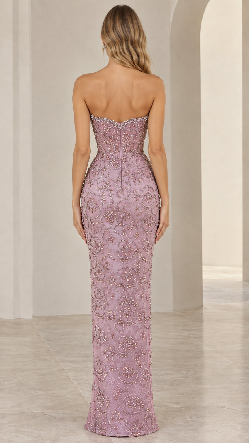 Back view of model showing strapless neckline and column fit in dusty rose gown