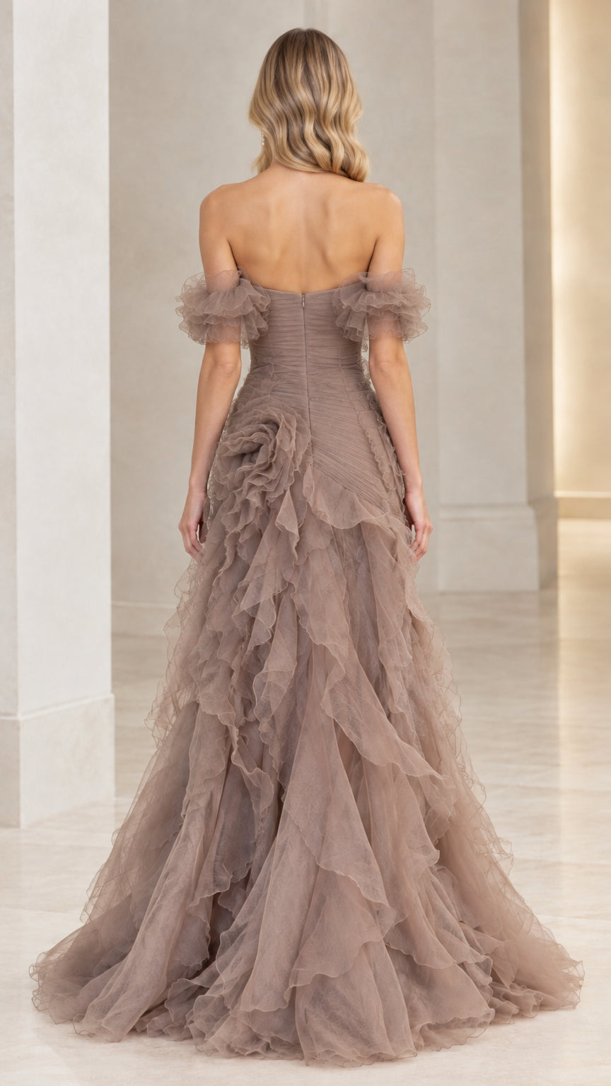Back view of model showing open back and tiered ruffle train in taupe