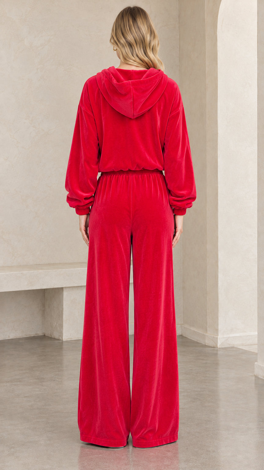 Back view of woman wearing red velour hoodie and wide leg sweatpants