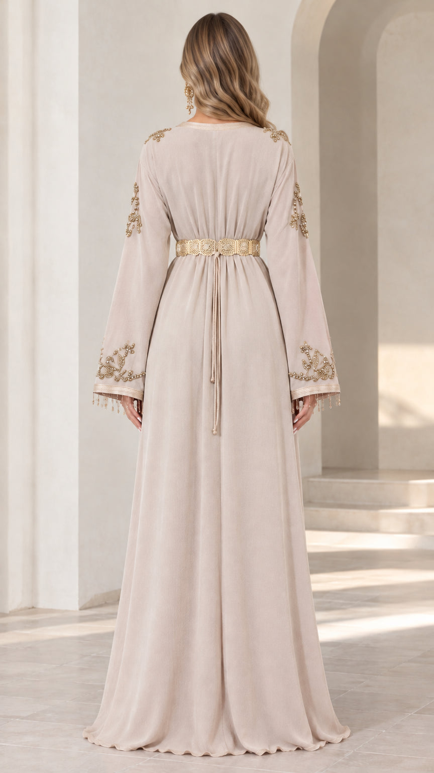 Back view of model wearing beige flowing caftan dress with gold belt