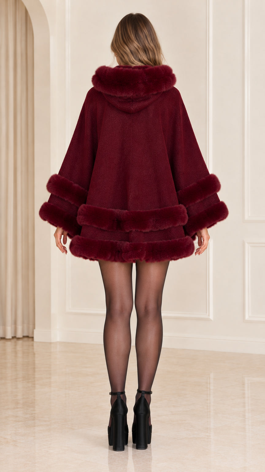 Back view of woman wearing burgundy faux fur trim hooded poncho wrap
